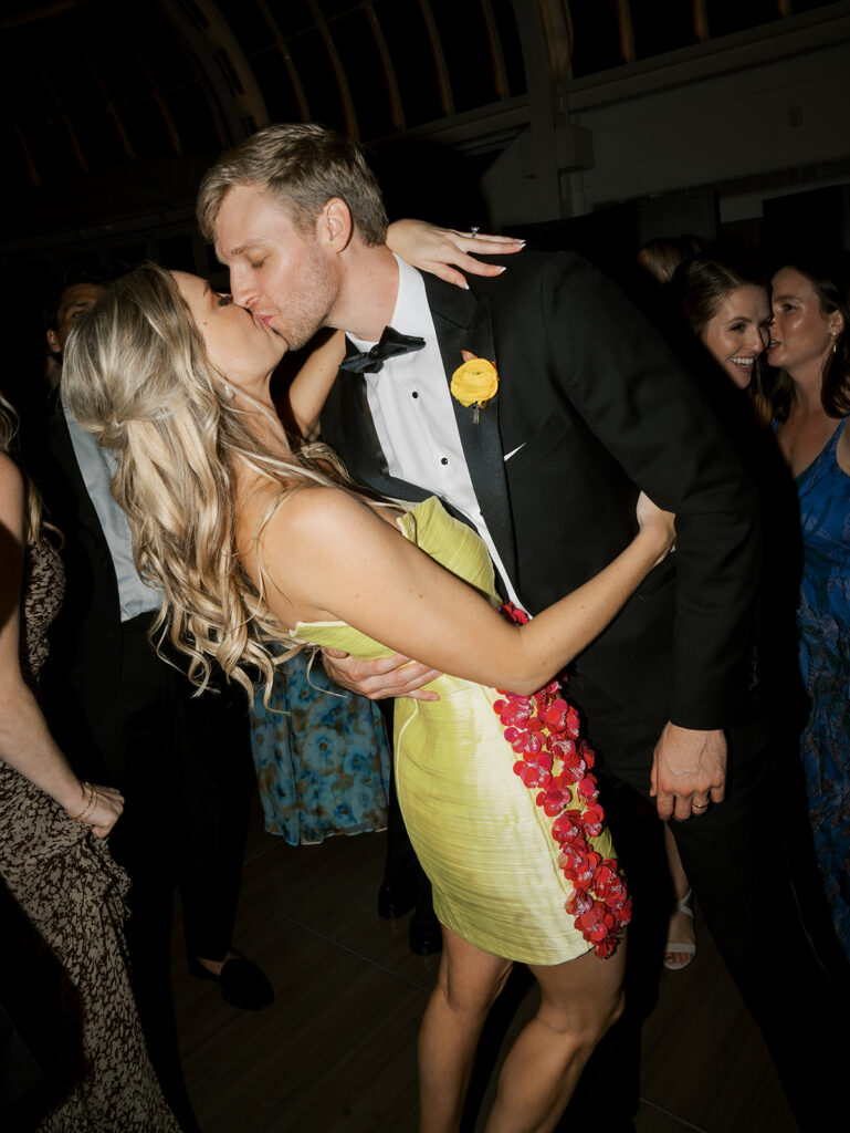 Bride and groom kissing. Bride is in yellow at her Brooklyn Botanic Wedding