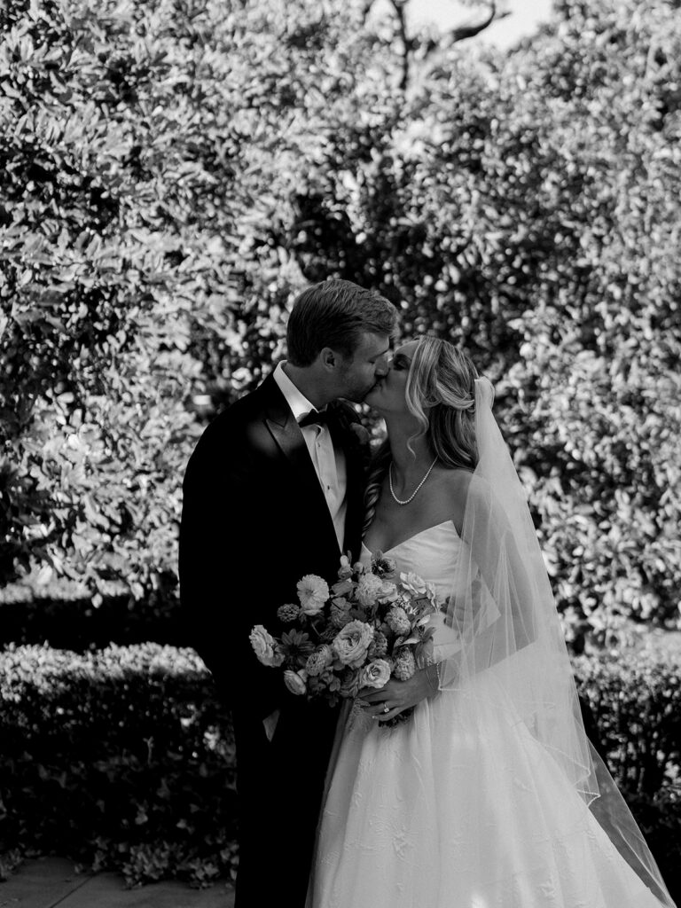 Bride and groom kissing in black and white.