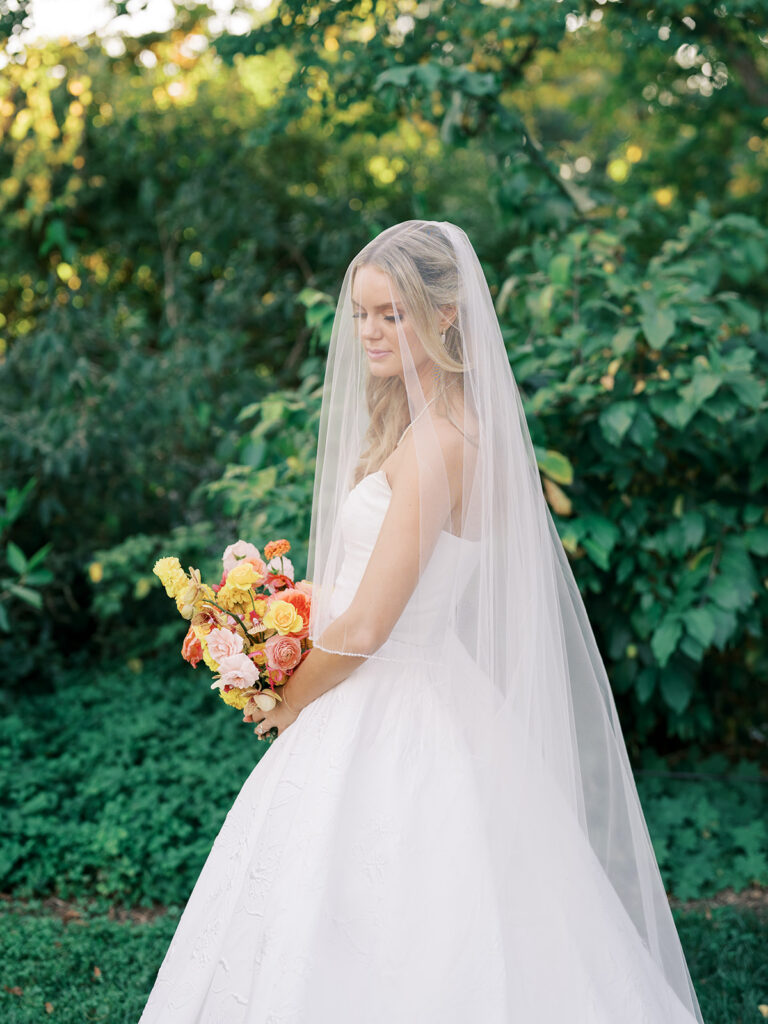 Bride looking down at flowers.