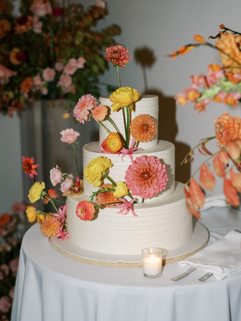The cake, three tier, decorated in floral bursts.