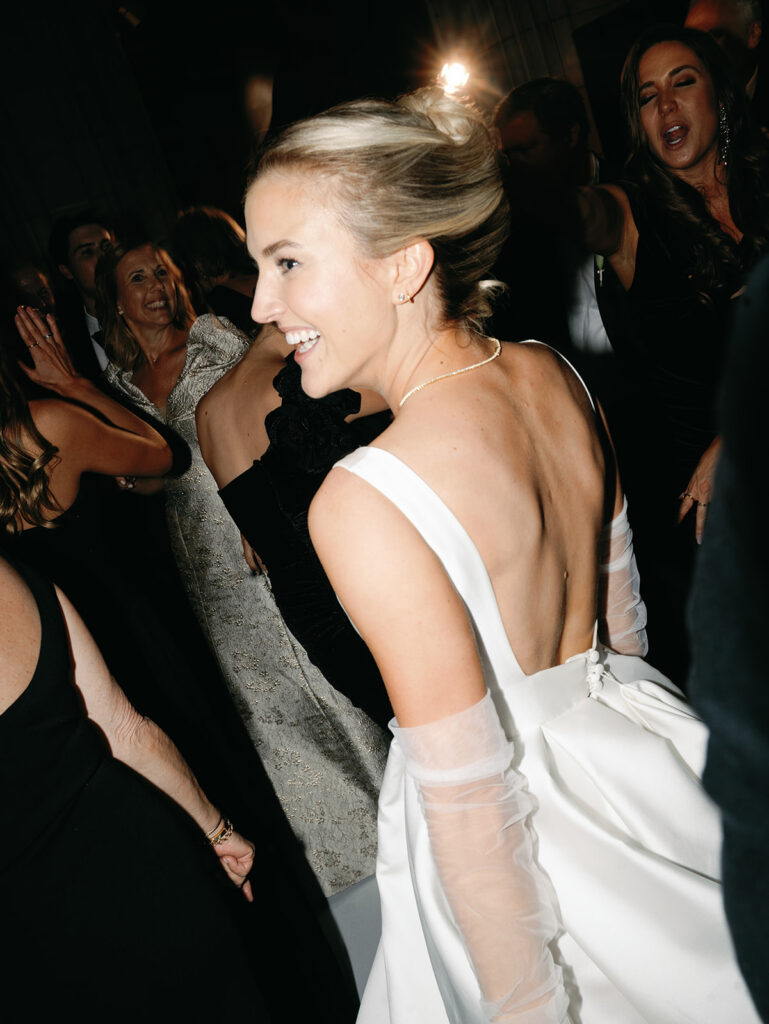 The bride on the dance floor looking over her shoulder laughing.
