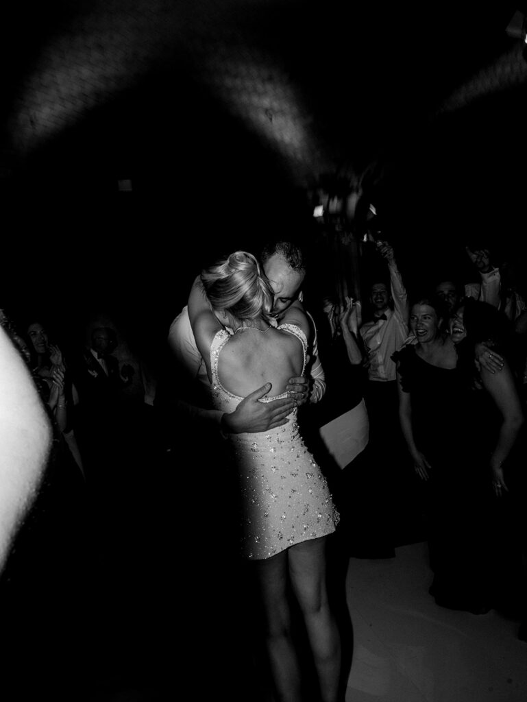 The bride and groom hugging in the middle of the dance floor.