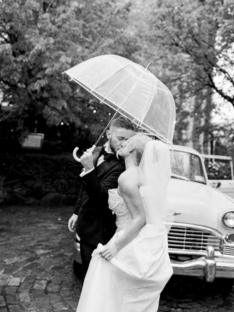 The groom giving the bride a kiss as they walk back into the river cafe.