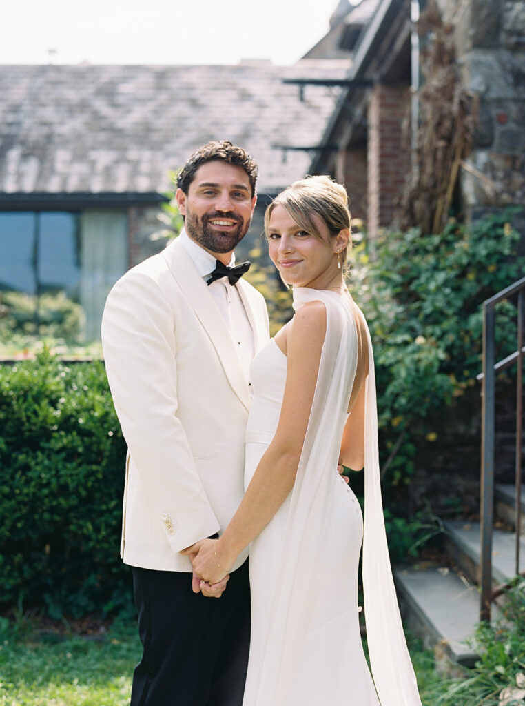Bride and groom pose for a portrait in the sunlight.