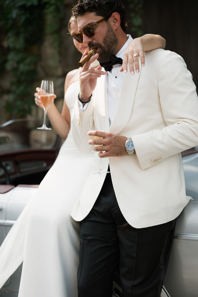 A close up of the bride and groom against the car.