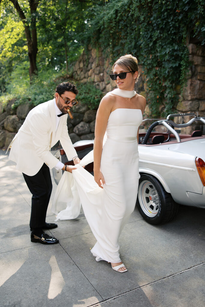 A candid walking photo of the bride and groom with the groom holding the bride's train.