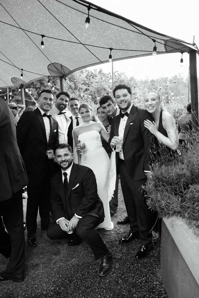 The bride and groom posing for a photo with friends during cocktail hour.