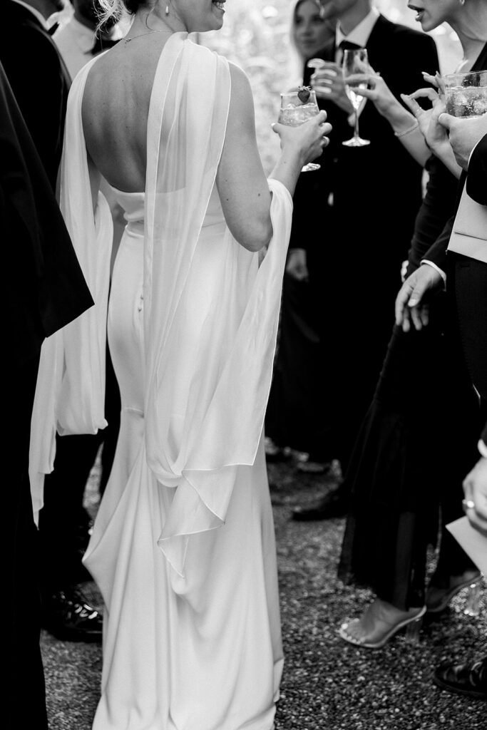 A close up documentary image of the bride during cocktail hour from the back.