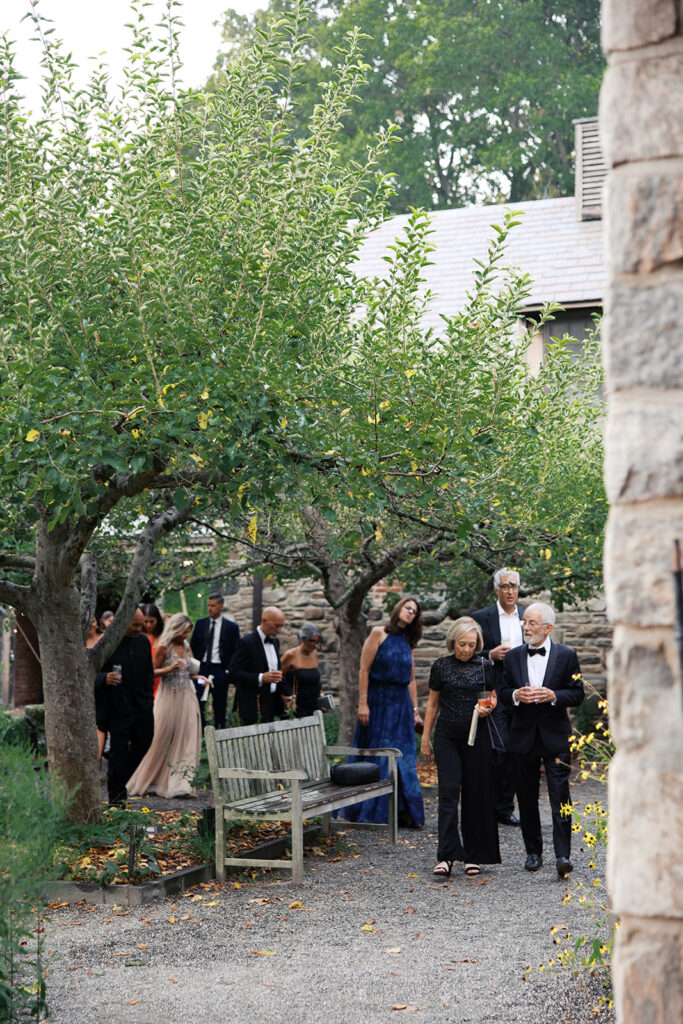 A pulled back view of the garden during cocktail hour with guests mingling.