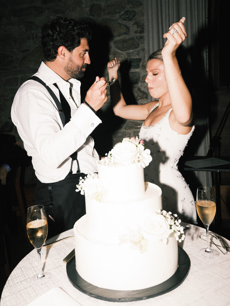 The bride and groom cutting the cake and dancing.