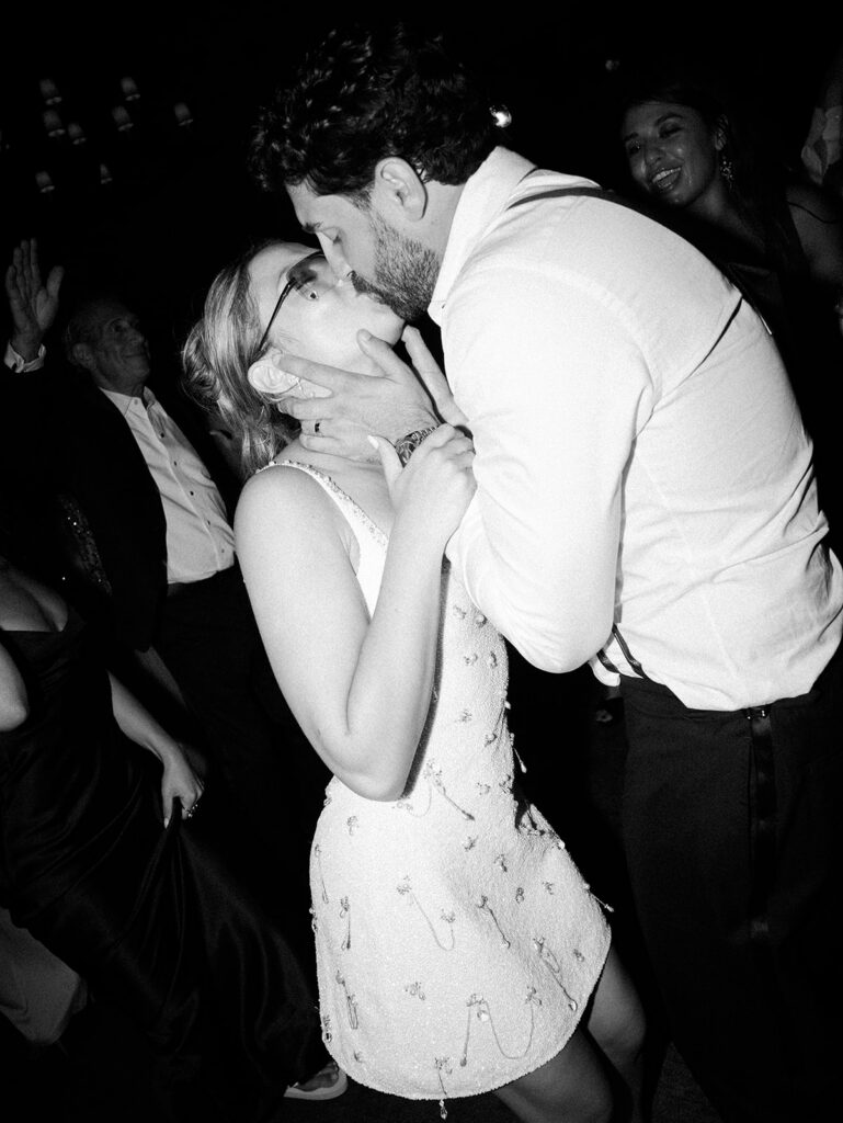 The bride and groom kissing on the dance floor.