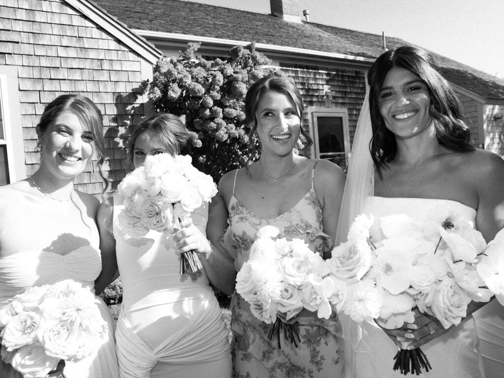 Bridesmaids gathered together for a candid portrait in black in white close up.